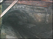 An old bridge over a stream, hidden under Leeds