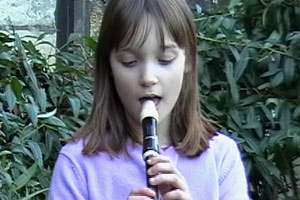 Melisa plays Silent Night on her recorder in the grounds of Gloucester Cathedral.