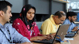 A visually impaired woman types at her laptop
