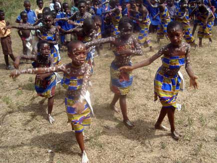 Schoolchildren dancing in colourful outfits and body paint