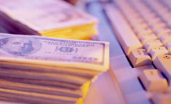 A computer keyboard and some dollar bills