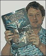 Adam Strickson holding up book
