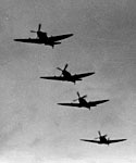 Black and white photograph showing four Spitfires soon after take off