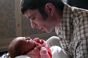 A young father holding a baby