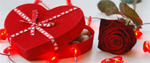 a red rose and box of chocolates surrounded by red lights