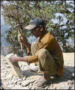Stone mason repairing a path