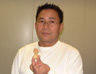 Sokphal Din holding the statue of Buddha that his mother gave him, and that was in her hands in the last moments of her life