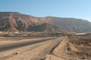 Desert road leading to Coptic monastery in the distance