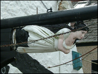 A Ship's Bust hangs above a shop in Falmouth