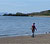 Cerddwr ar draeth Niwbwrch