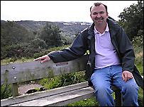 Stephen sitting on a wooden bench