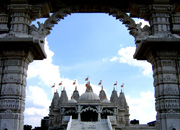 Swaminarayan Hindu temple seen from an ornately arched gateway