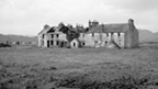 Black and white view of a two-storey block of workers' houses at Bonawe Furnace. the centre of the block is abandoned with no roof and missing windows