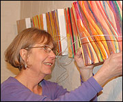 Brenda hanging a painting of Jaywick 
