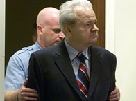 Slobodan Milosevic is led into the UN War Crimes Tribunal