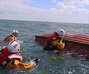 Neil Oliver with the help of the RNLI attempting to right a boat