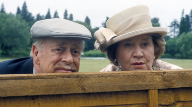 Richard and Hyacinth Bucket peering over a fence
