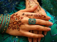 An Asian woman's hands decorated with henna patterns