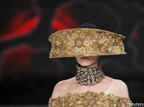 A model wears a gold headpiece by British designer Sarah Burton.