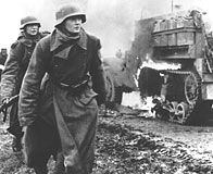 Two German soldiers and a burning US vehicle