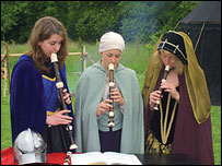 Three women playing recorders in period dress