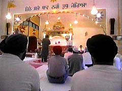 Sikh men seated inside a Gurdwara