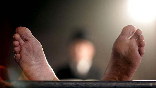 A still from the Operation Mincemeat programme of a dead body's feet on a mortuary table.