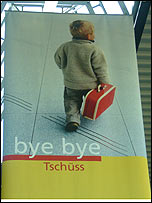 A sign featuring a child carrying a suitcase and adorned with the words bye bye and tschüss