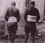 Photo of two American deserters wearing signs marking them as deserters