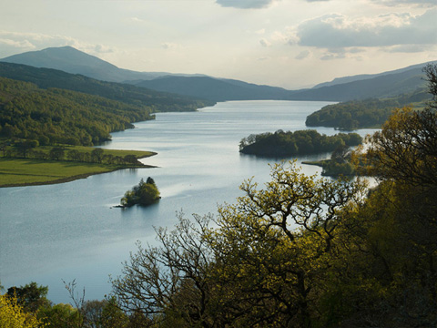 Colour view across the broad expanse of Loch Tummel, with hills around and peak of Schiehallion behind.