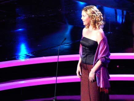 Elin Manahan Thomas, in evening wear and pink shawl, singing on stage
