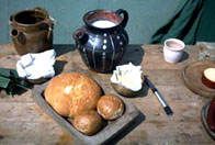 A image of a a selection of bread, butter and jug of milk