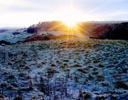 Sun rising over snowy Scottish hills