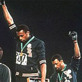 Tommie Smith and John Carlos raise their gloved fists in a Black Power salute