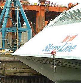 A diminutive worker in red overalls perches on the nose of the HSS Ferry