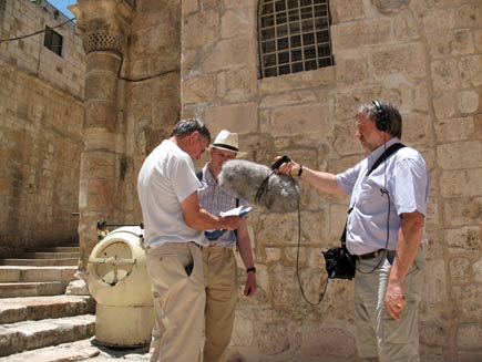 Ernie Rea, Philip Billson and Phil Booth standing in front of the stone walls of the church