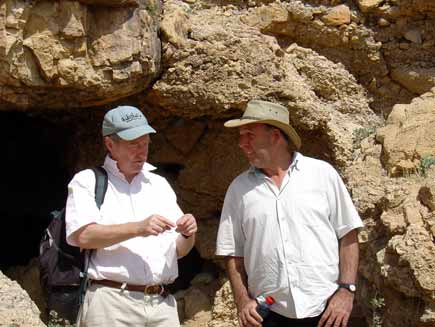 Roger Bolton (left) and Prof Hanan Eshel stand in front of a low cave