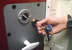 A warden locks a prison cell