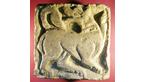 Norman carving of a dog chasing its tail