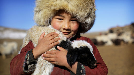 Bachgen yn anialwch Gobi, Mongolia gyda'i afr anwes © Timothy Allen