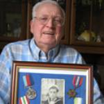 A recent photograph of Mr. Ivor Chappell with his framed photograph and medals awarded for serving in the D.E.M.S. during WWII