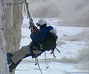 Nicholas Crane investigating the erosion of chalk on a cliff face