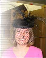Lucy models a hat.