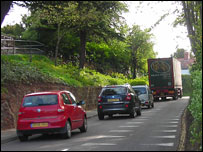A lorry navigating the lane by the church in Ruyton XI Towns