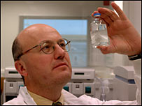 Scientist in laboratory holding a bottle