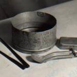 Tommy's eating utensils cobbled together in a Jap prison camp to hold his meagre daily ration of rice