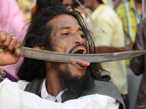 A man pushes a sword across his tongue