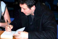 Stephen Jones yn arwyddo copi o'i lyfr noson ei gyhoeddi