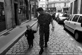 A British marine walking with a child.