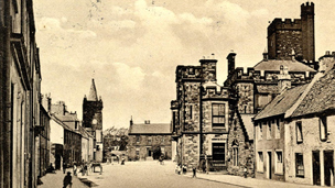Black and white view along High Street, Kirkcudbright, showing the Tolbooth and the County Building.
